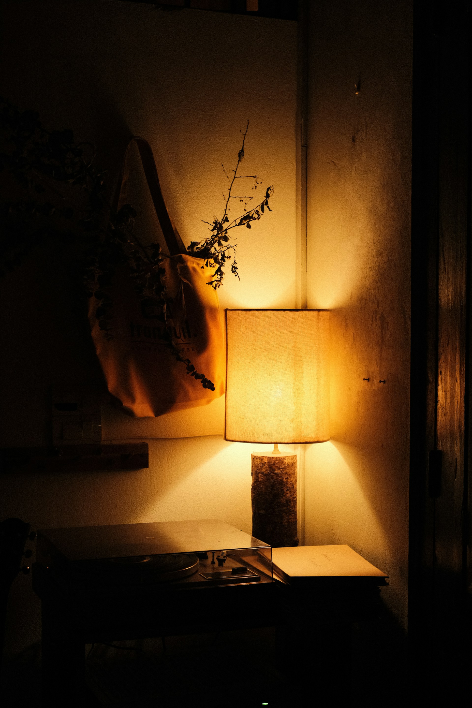 a dark room with a lamp and a table