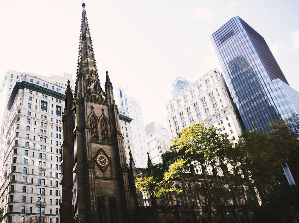 a tall church tower towering over a city filled with tall buildings