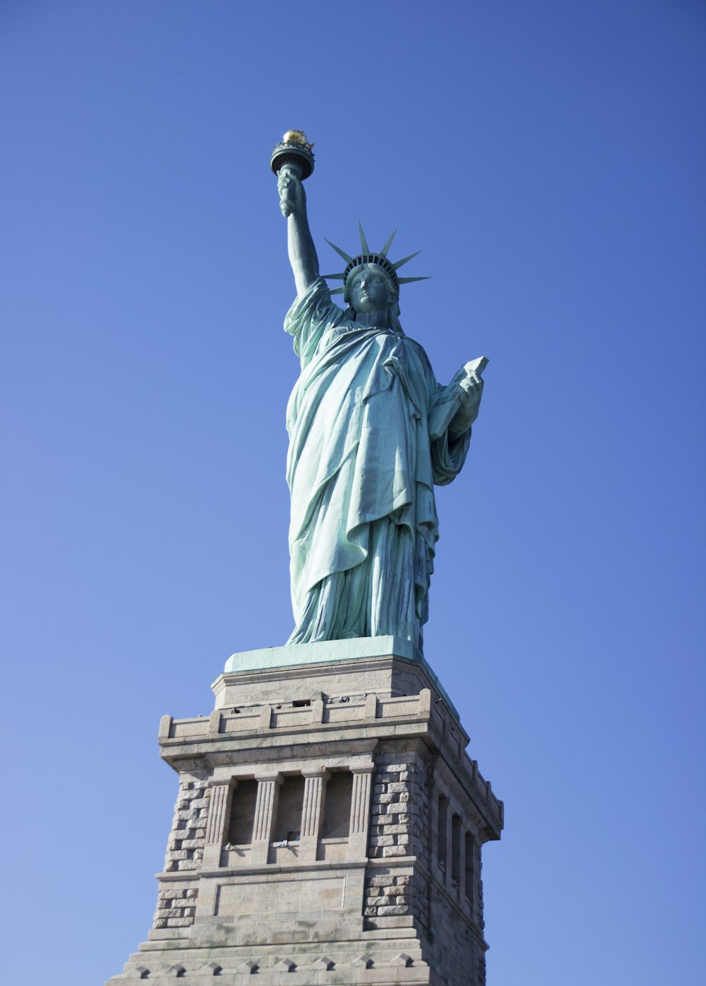 the statue of liberty is shown against a blue sky