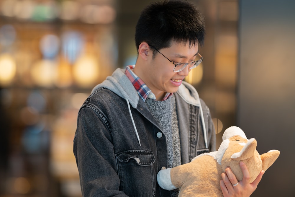 a man holding a stuffed animal in his hands