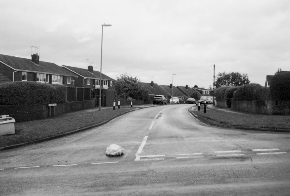 a black and white photo of a street with houses