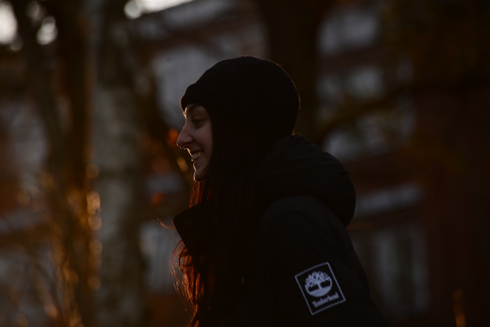 a woman in a black hoodie is laughing