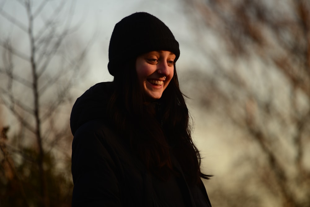 a woman in a black jacket and a black hat