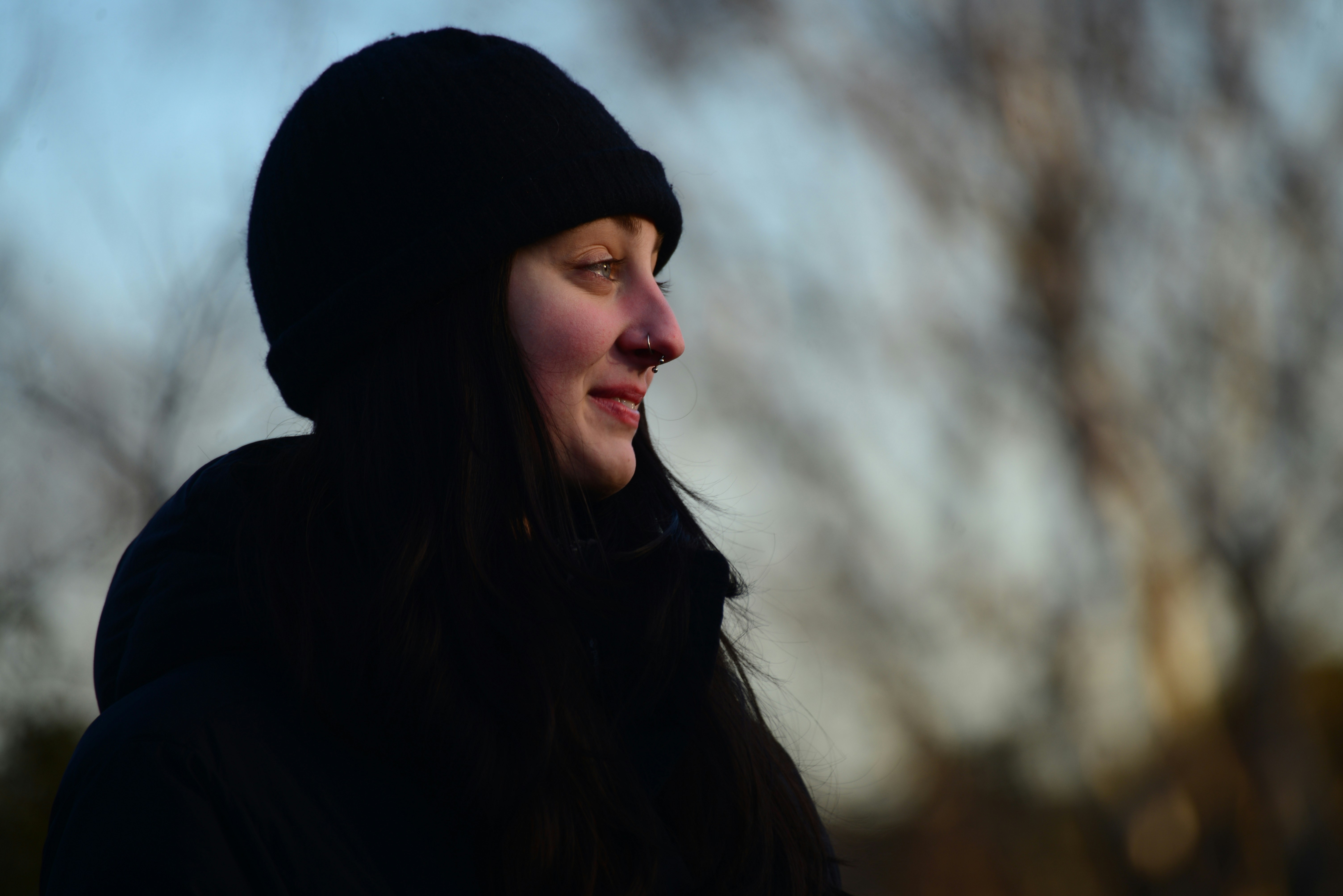 a woman wearing a black coat and a black hat