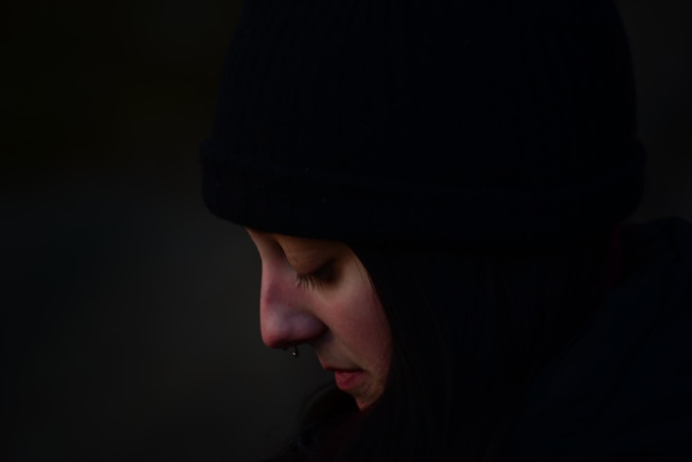 a woman in a black hoodie looking down at her cell phone