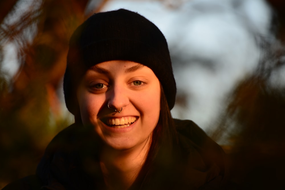 a woman wearing a beanie smiles at the camera