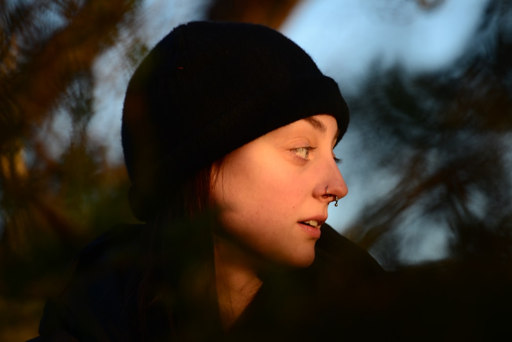 a woman wearing a beanie looking off into the distance