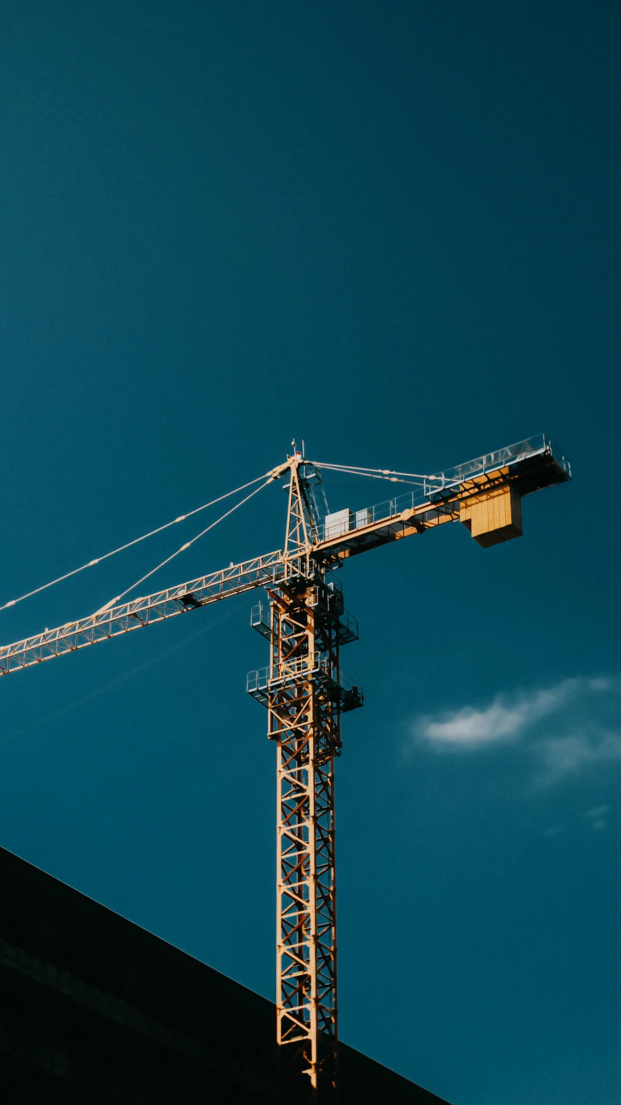 Pile driving crane and hammer over water at dusk