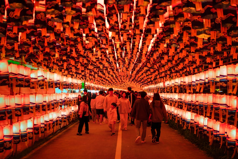a group of people walking through a tunnel of lights