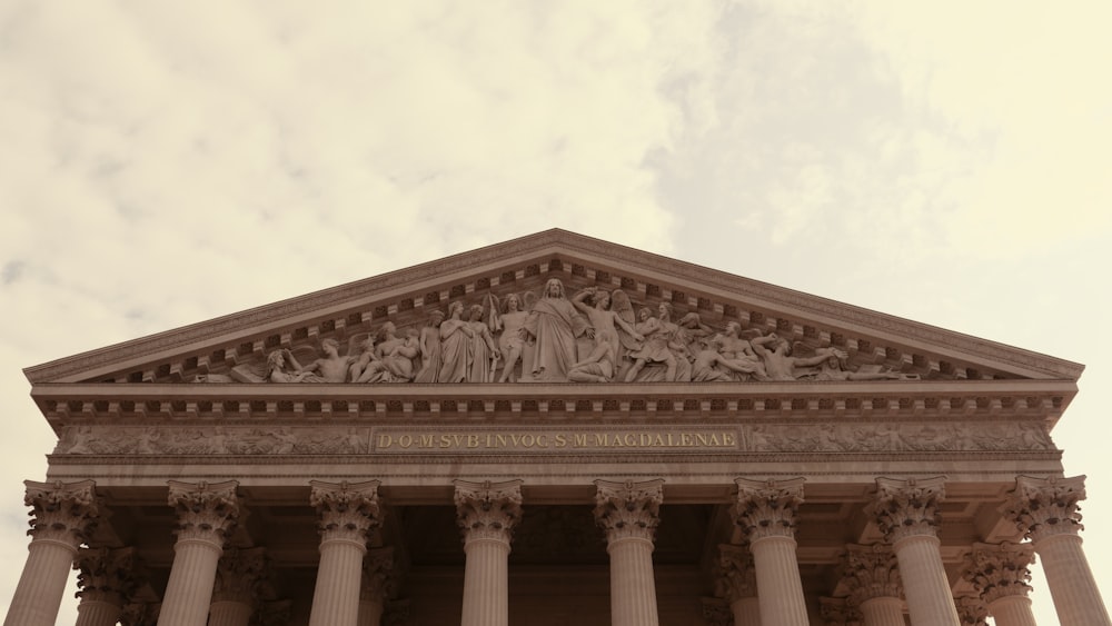 a large building with columns and a sky background