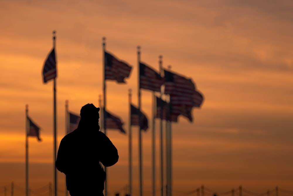 a man standing in front of a row of american flags