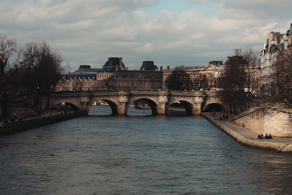 a bridge over a body of water with buildings in the background