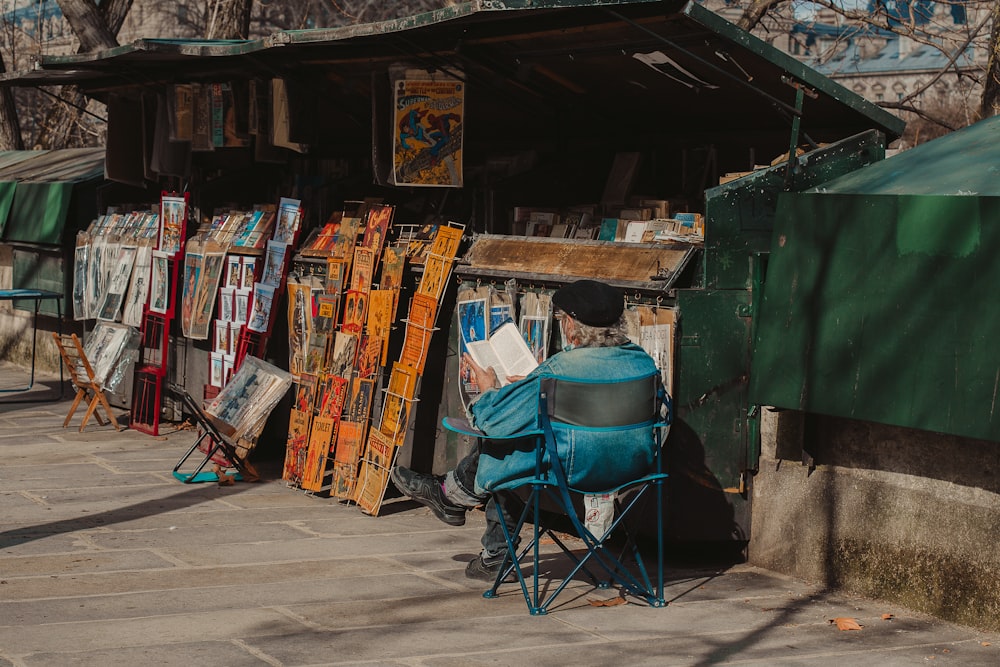 a man sitting in a chair in front of a store