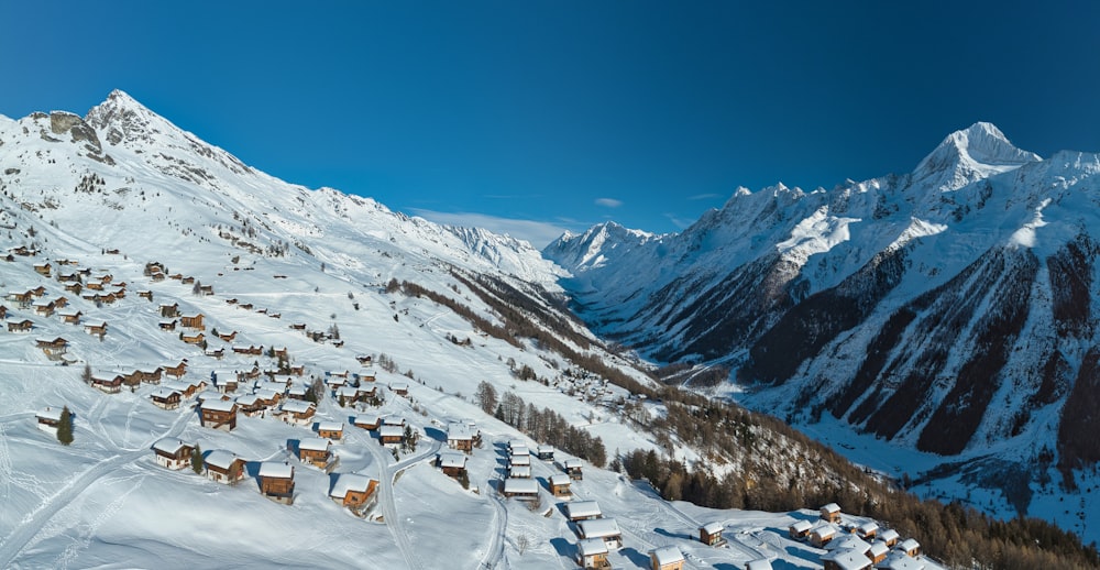 Ein schneebedeckter Berg mit einer Reihe von Häusern darauf