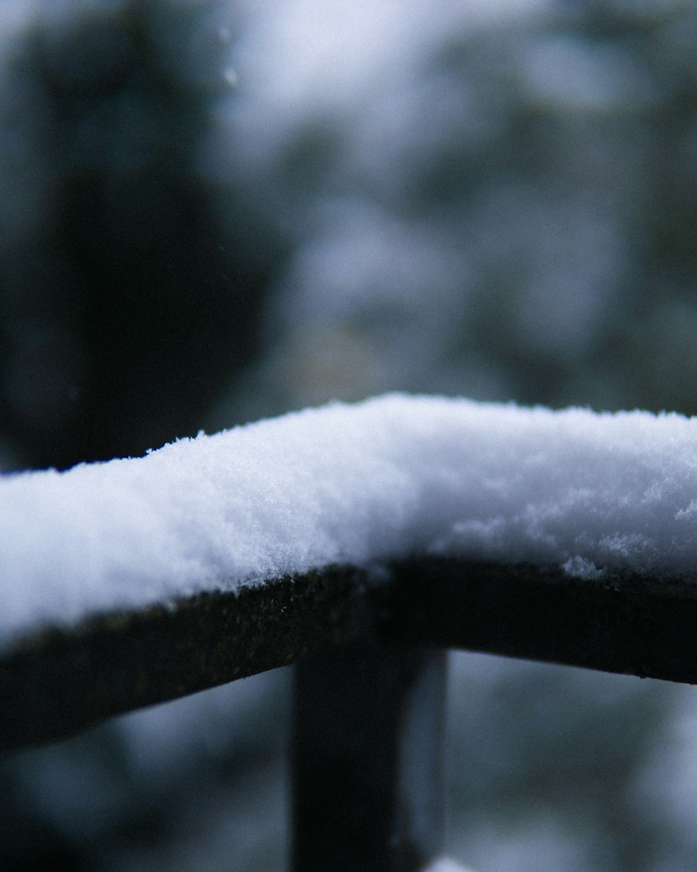 um close up de neve em um trilho de metal
