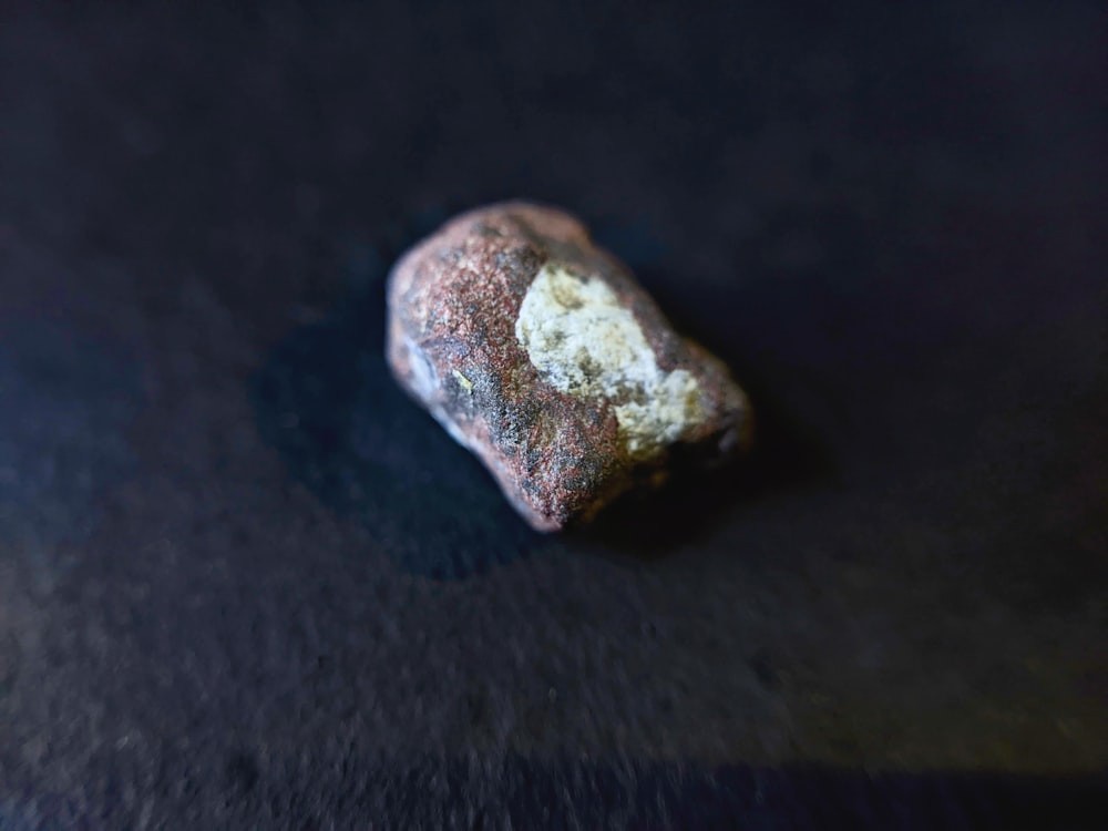 a rock sitting on top of a black surface