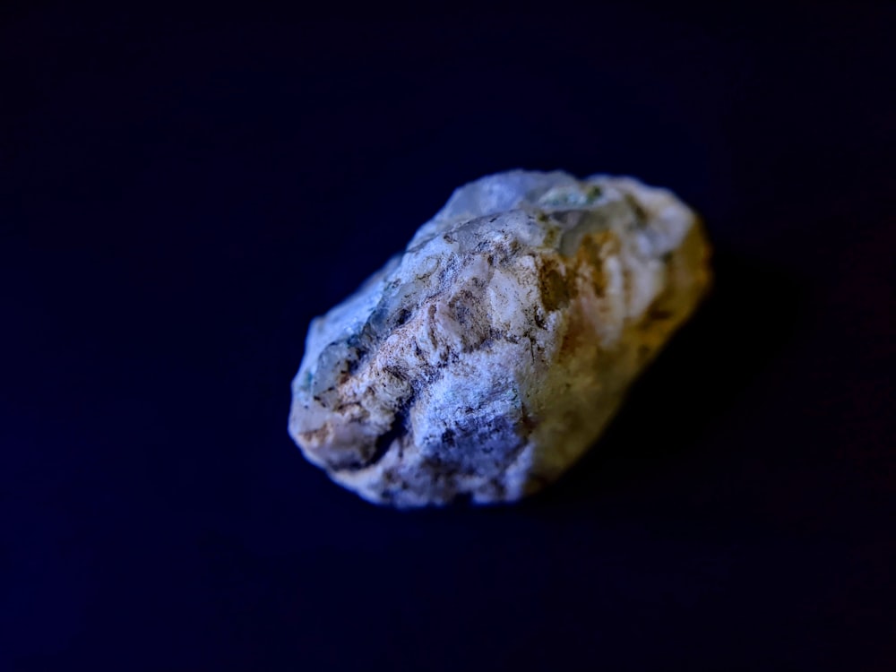 a piece of rock sitting on top of a black surface