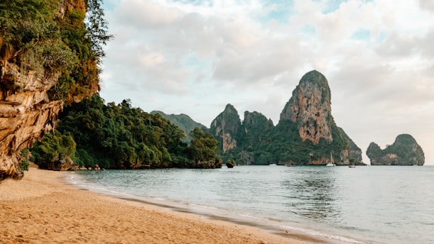 a sandy beach next to a body of water