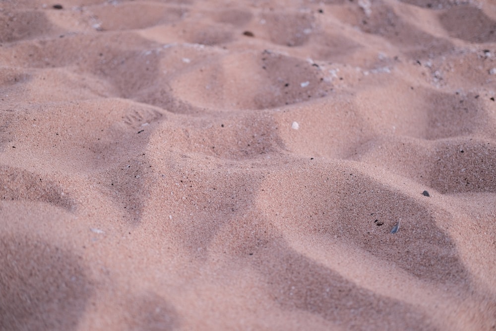 a close up of a sandy beach with footprints in the sand