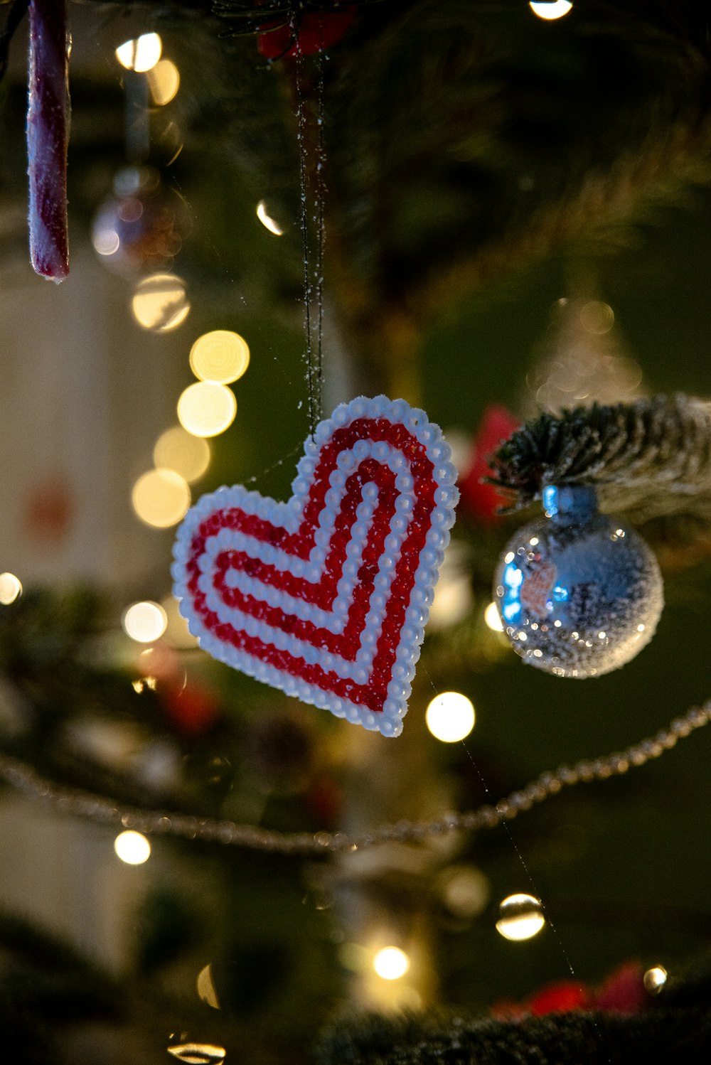 a heart ornament hanging from a christmas tree