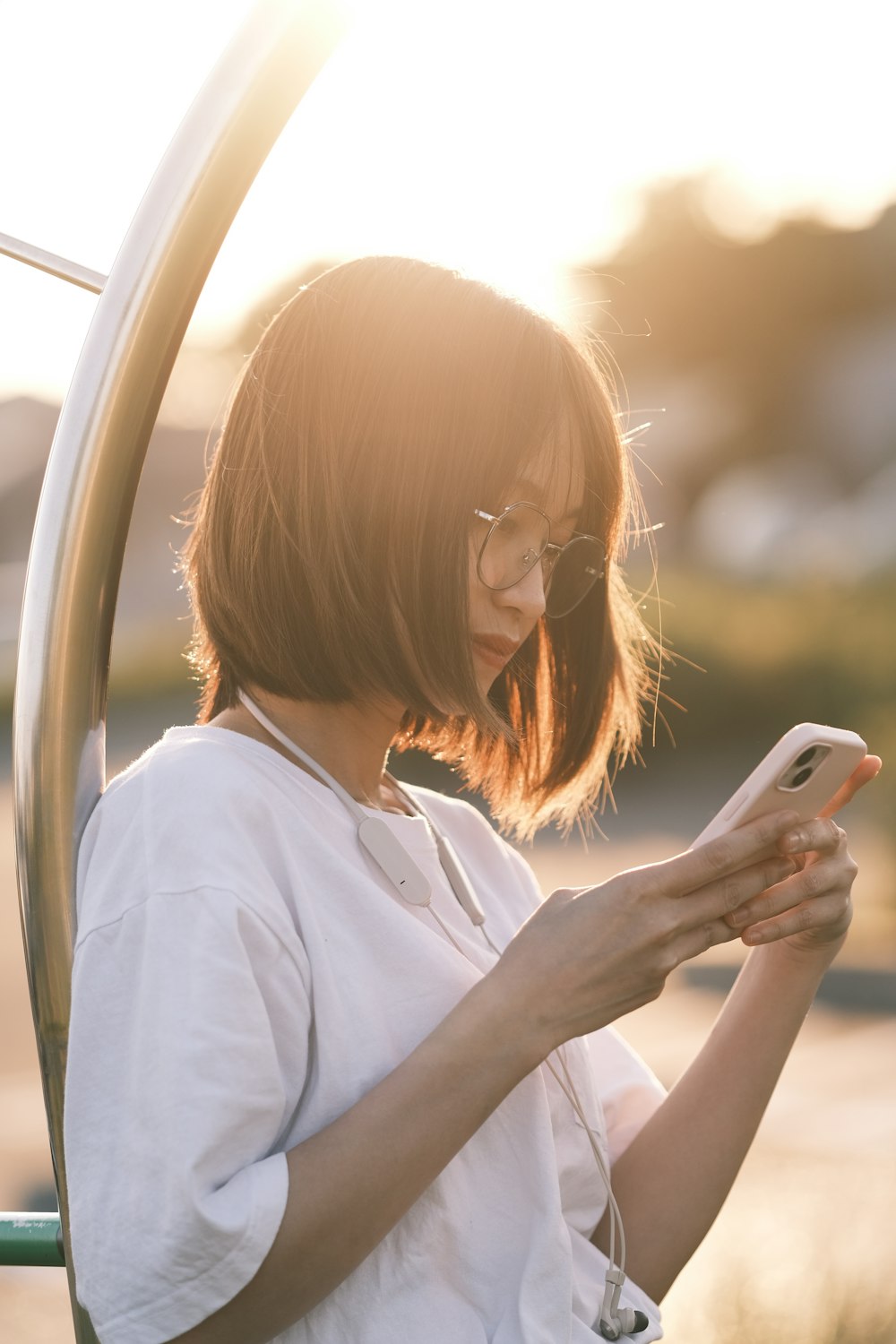 a woman in a white shirt using a cell phone