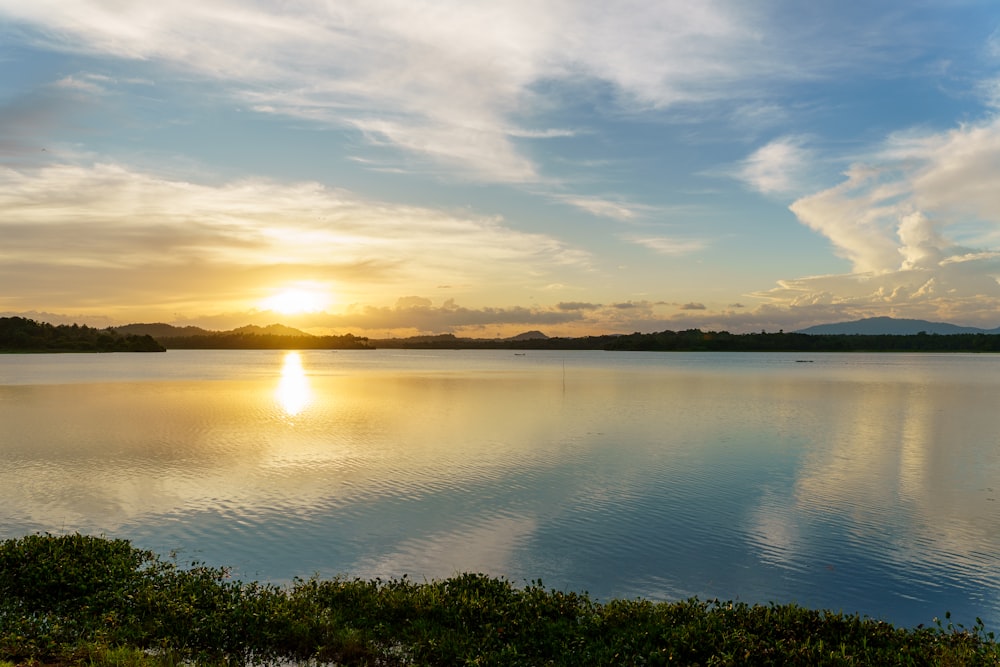 the sun is setting over a large body of water