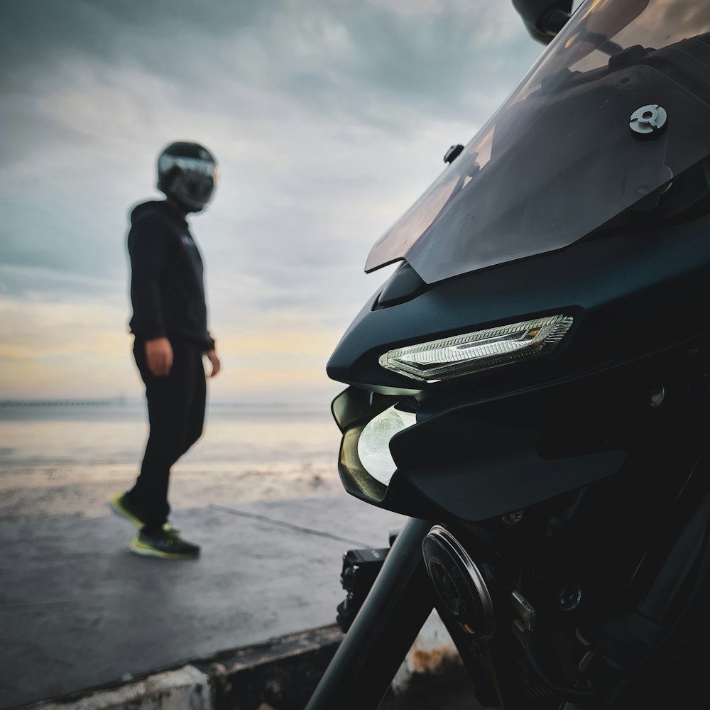 a man standing next to a parked motorcycle