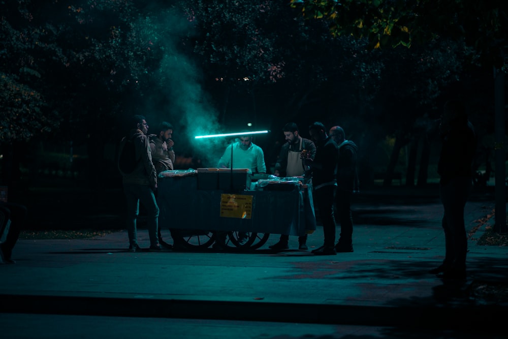 a group of people standing around a table in the dark