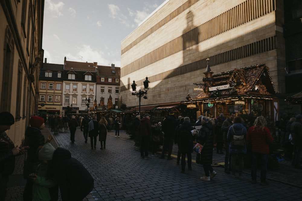 a crowd of people walking down a street next to tall buildings