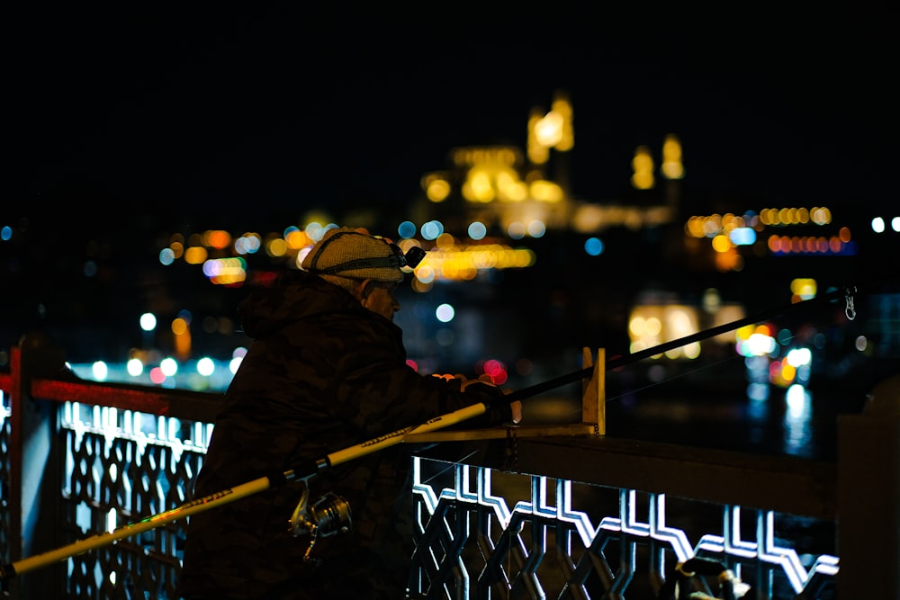 a person standing on a railing at night