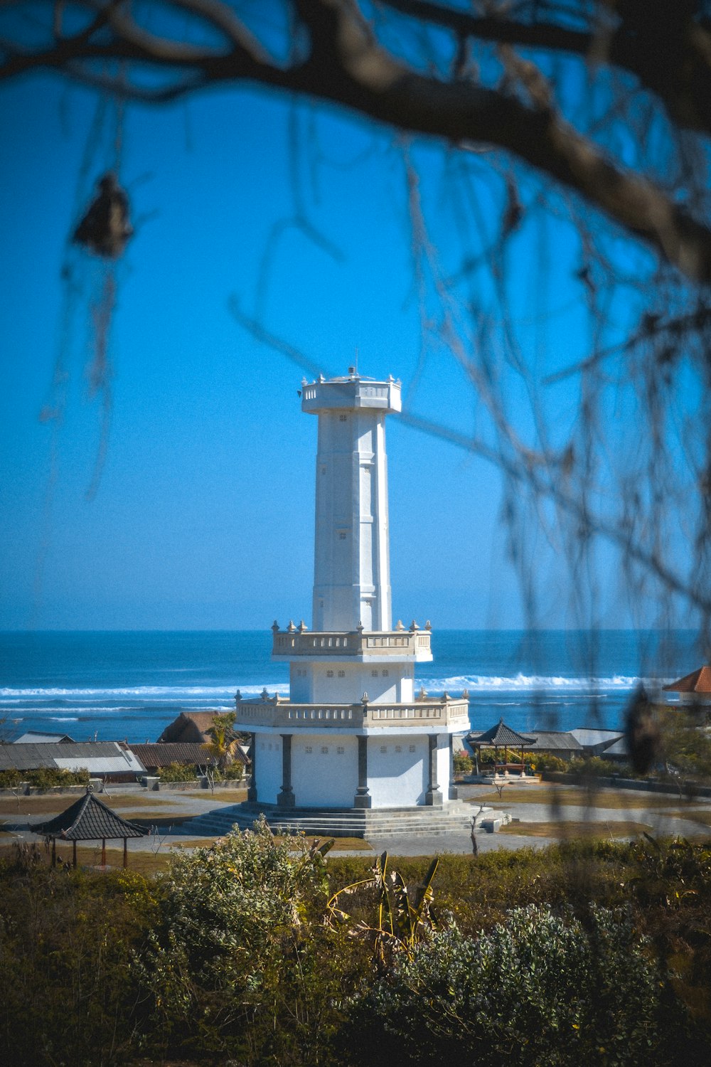 una alta torre de reloj blanca sentada junto al océano