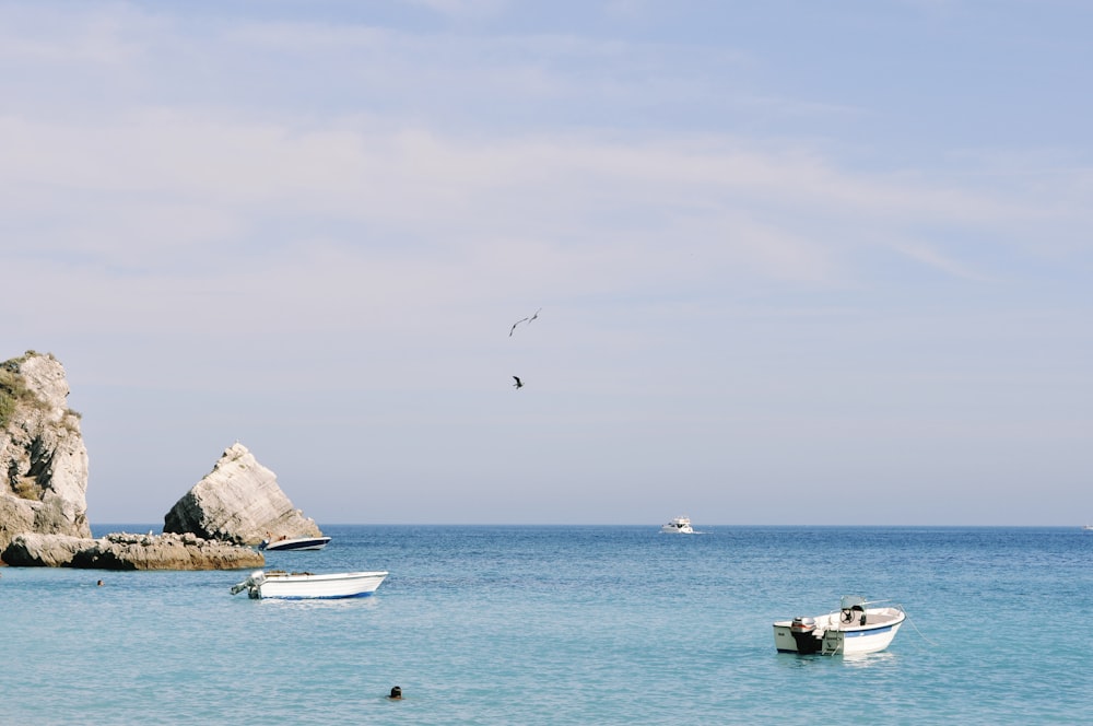 a couple of boats floating on top of a body of water