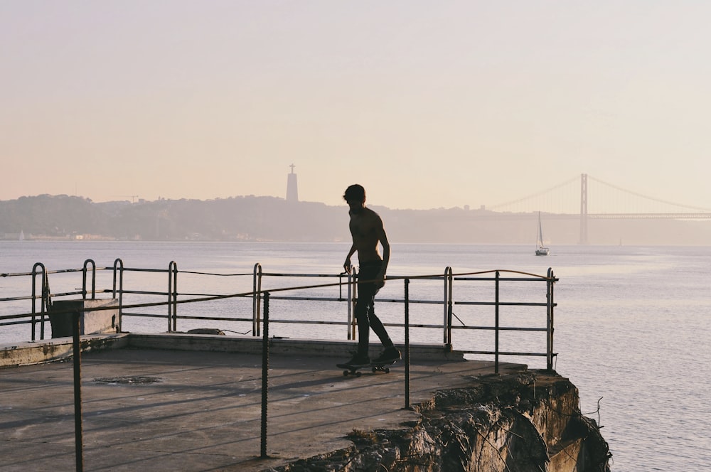 a man riding a skateboard on top of a wooden pier