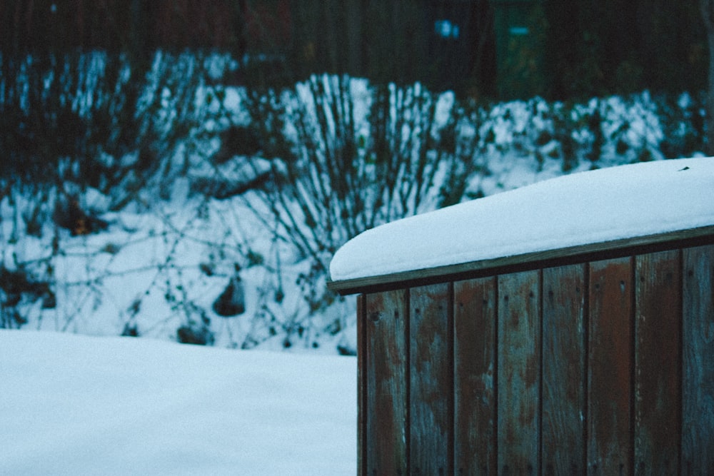 a wooden outhouse with snow on top of it