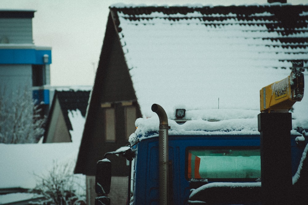 a blue dumpster sitting next to a building covered in snow