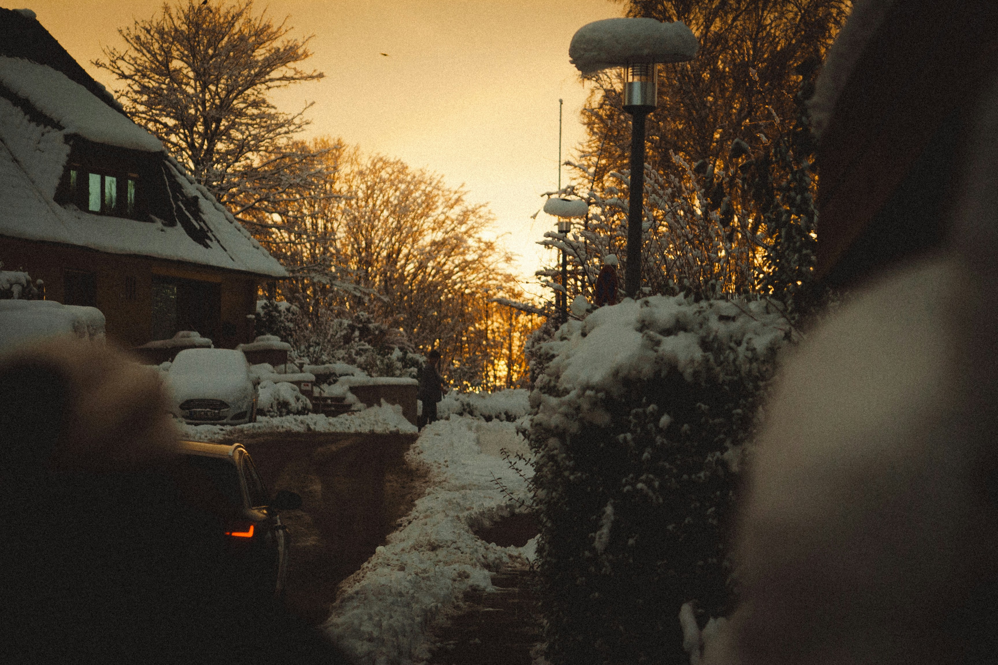 a snow covered street next to a building