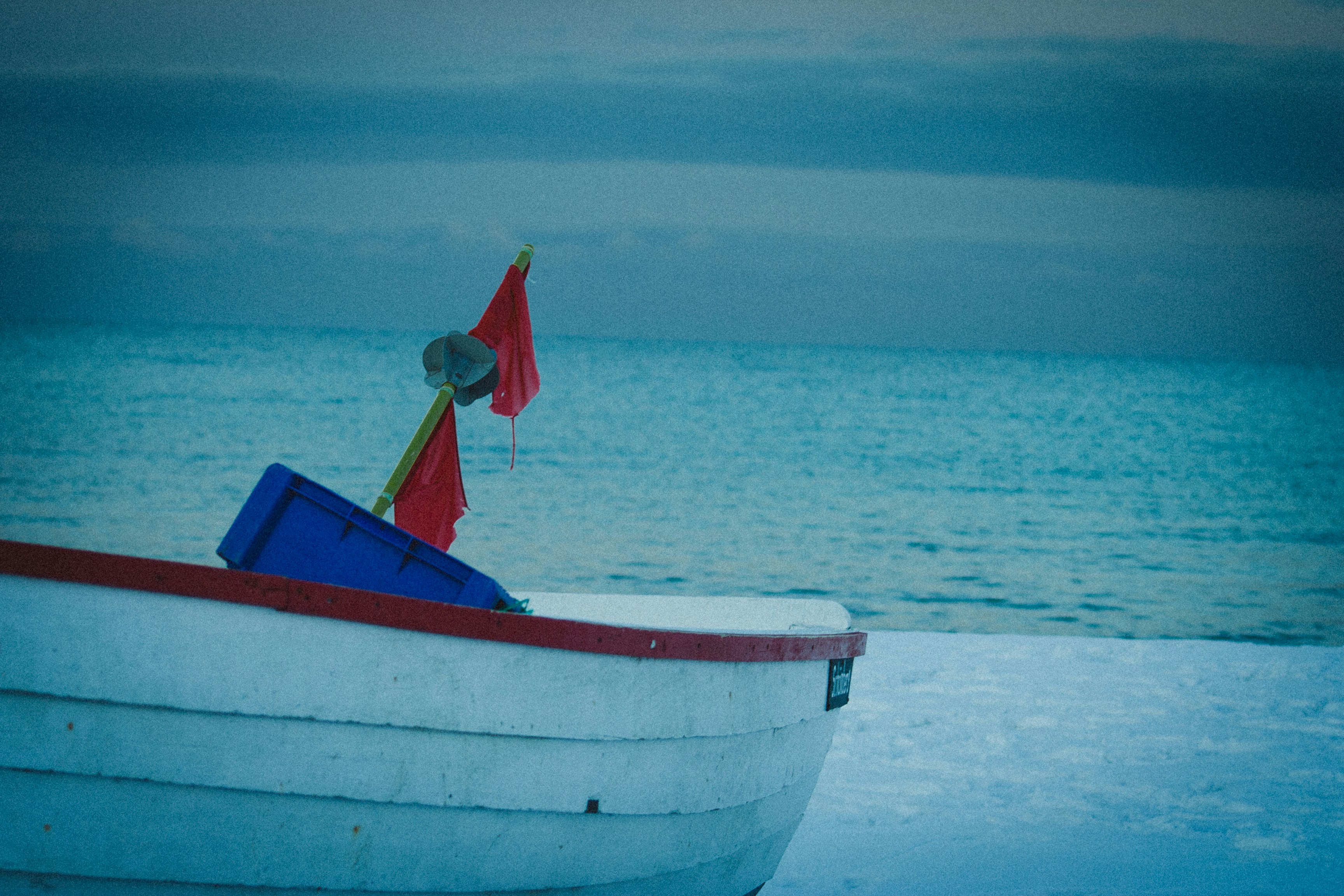 a small boat sitting on top of a sandy beach