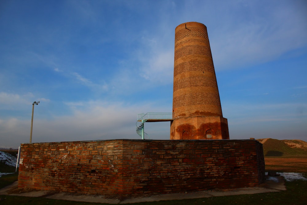 a tall brick tower sitting next to a brick wall