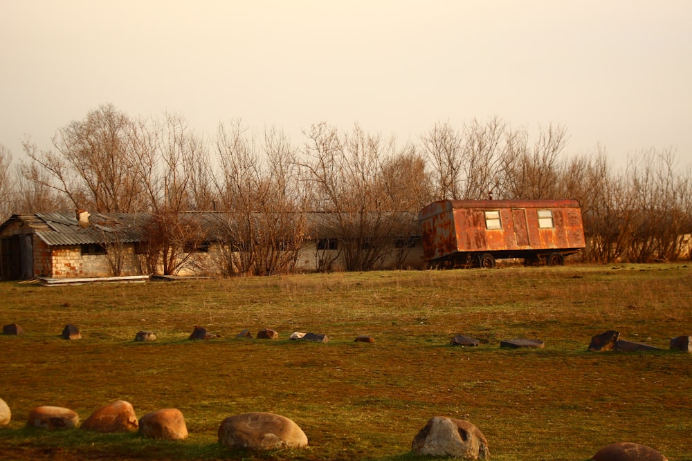 a field with rocks and a building in the background