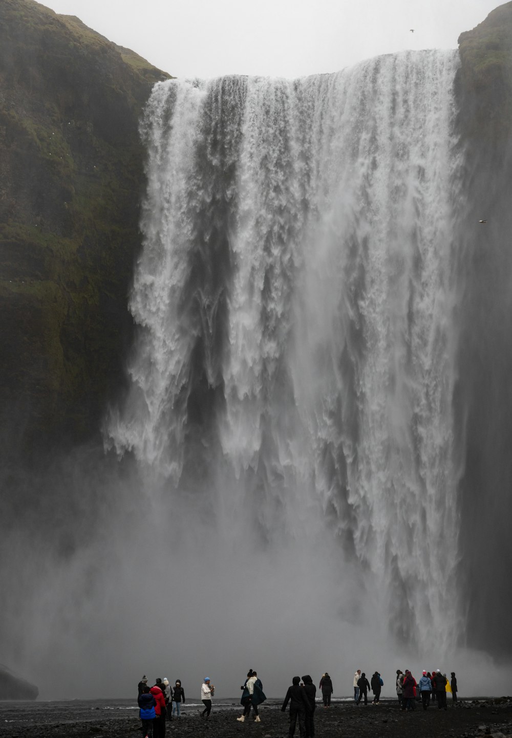 eine Gruppe von Menschen, die vor einem Wasserfall stehen