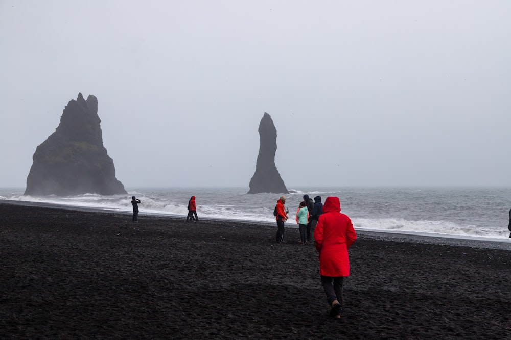 a group of people standing on top of a beach