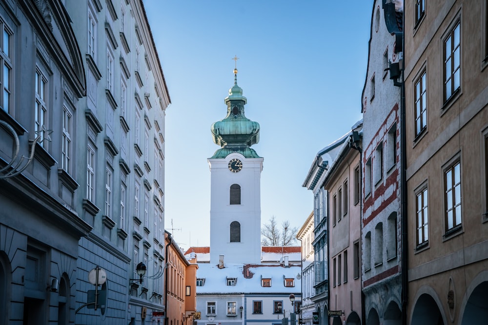 a clock tower in the middle of a narrow street