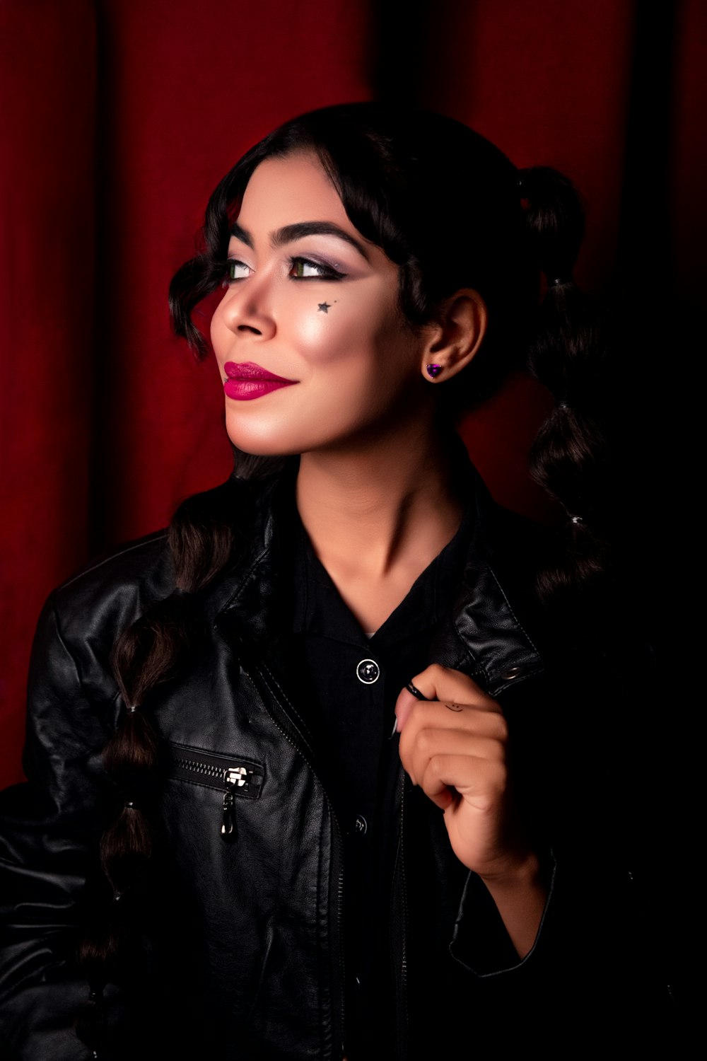 a woman wearing a black leather jacket and red lipstick