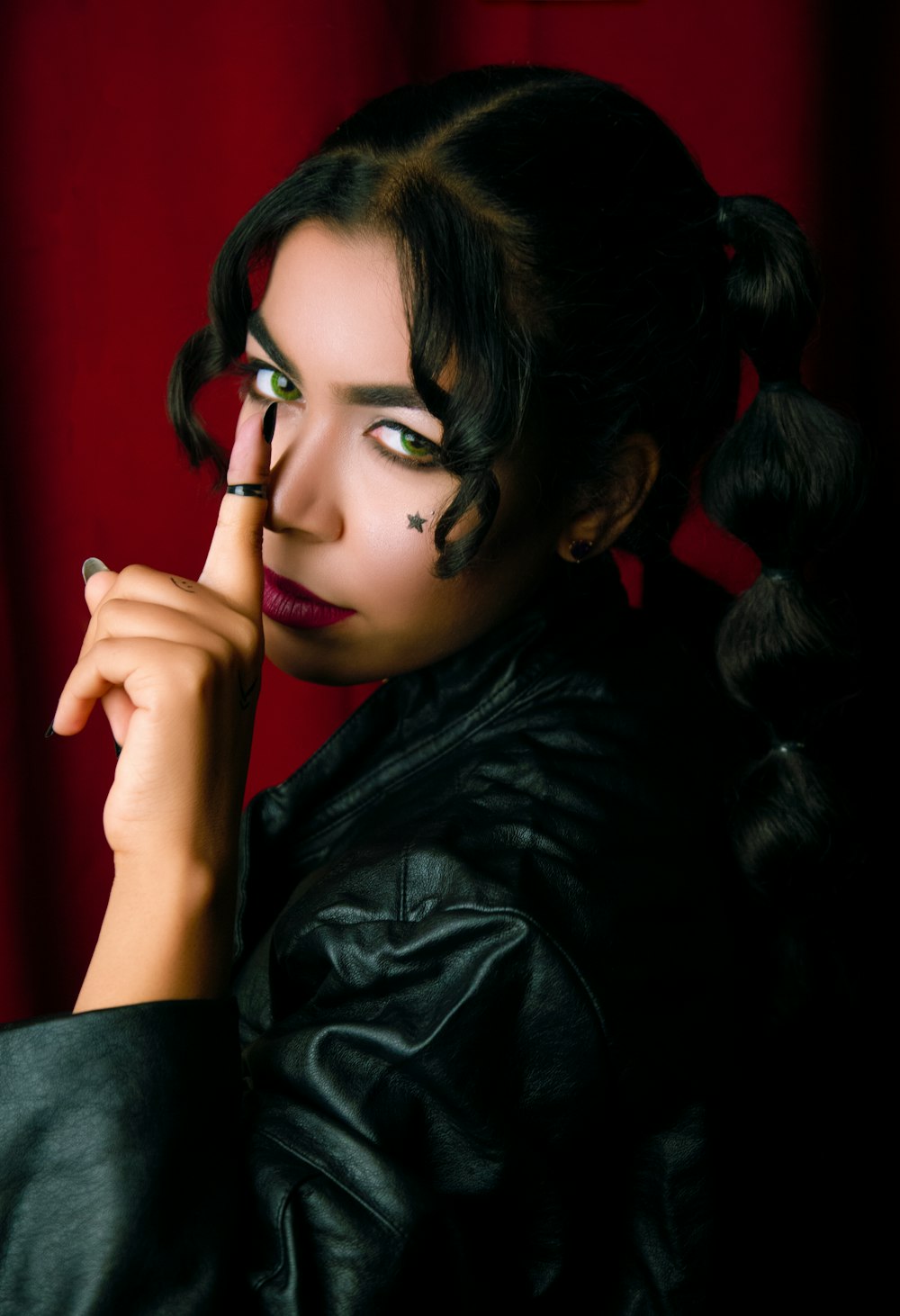 a woman with black makeup and piercings on her face