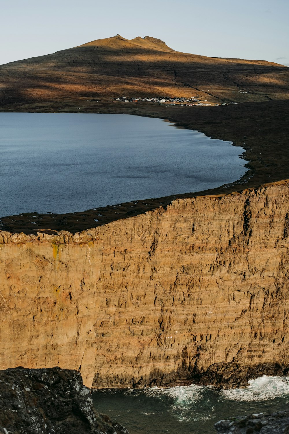 a large body of water sitting next to a cliff