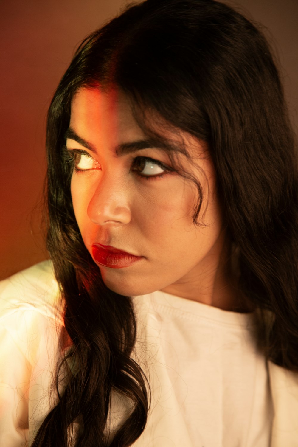 a woman with long black hair wearing a white shirt