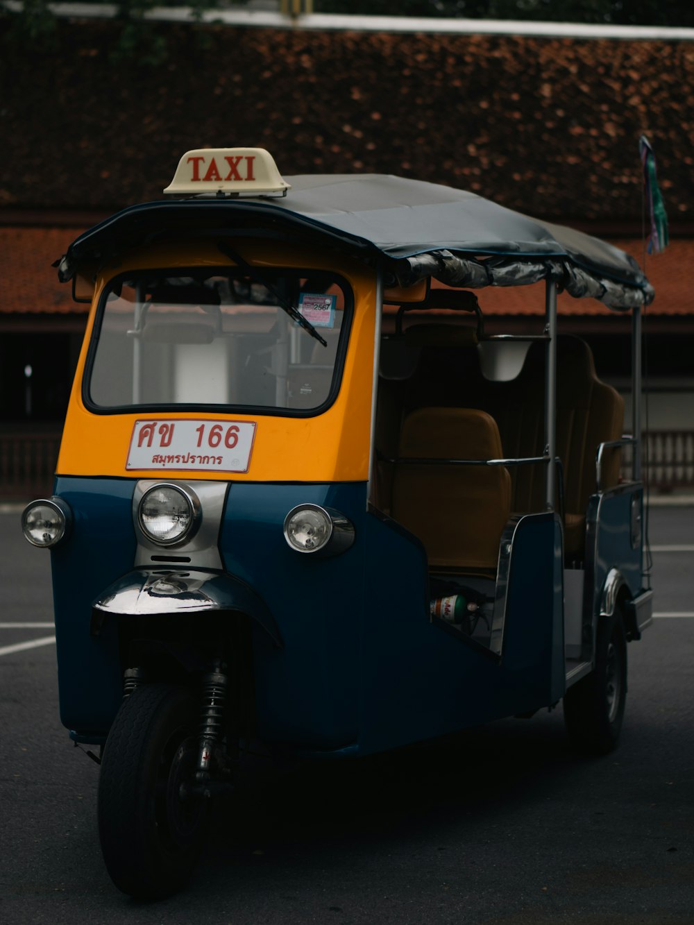 a yellow and blue taxi is parked in a parking lot