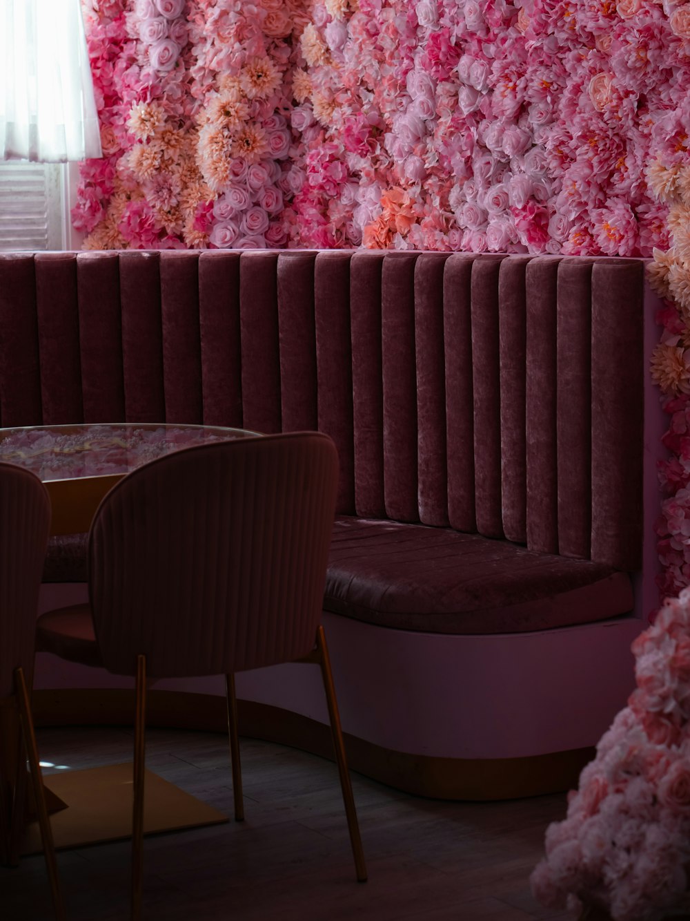 un ristorante con una parete floreale dietro lo stand