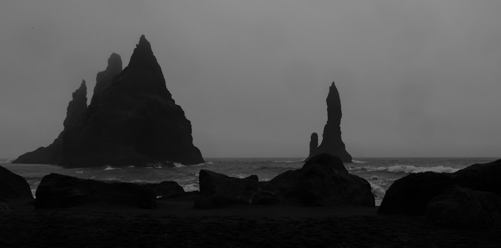 a black and white photo of some rocks in the water