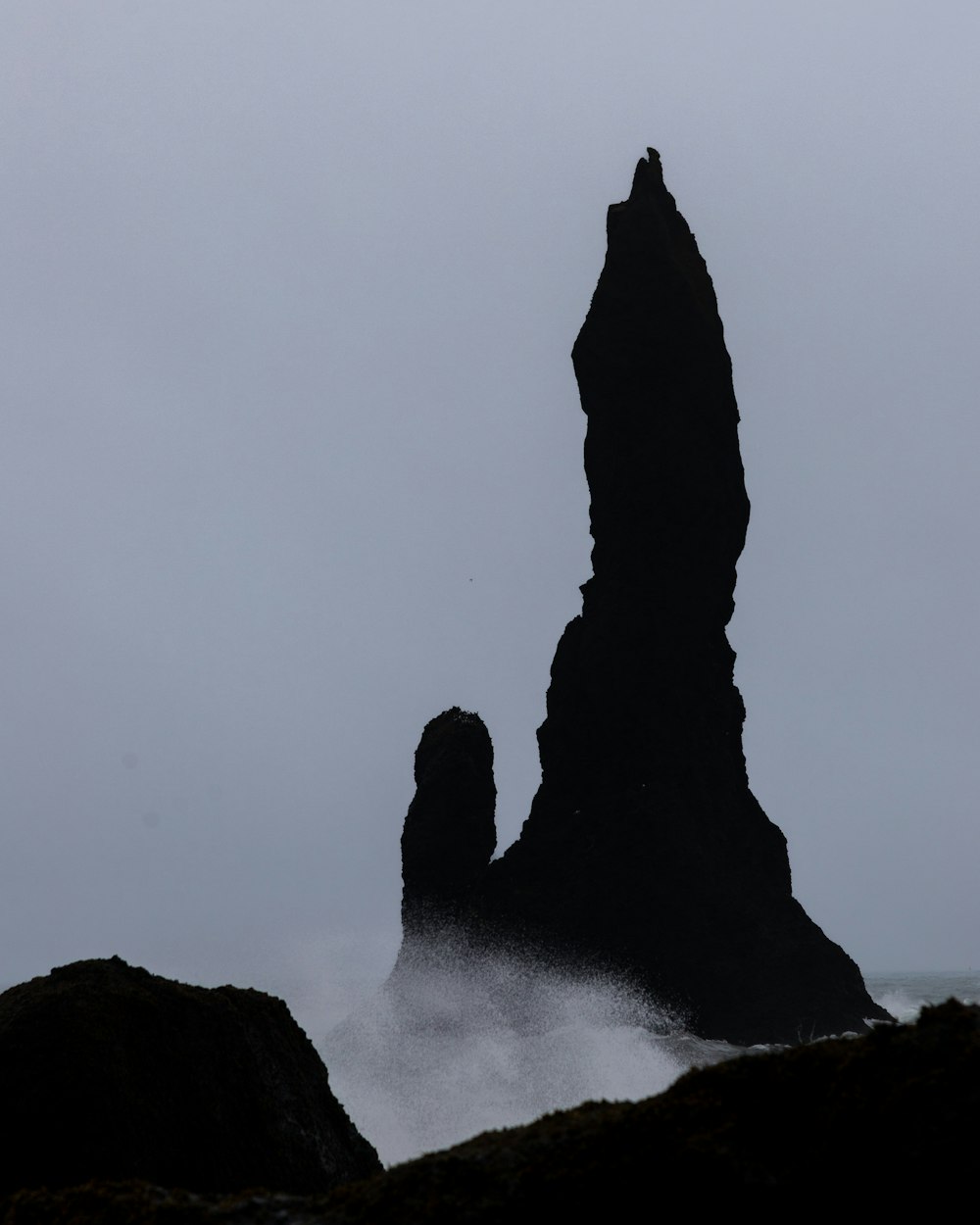 a large rock sticking out of the ocean